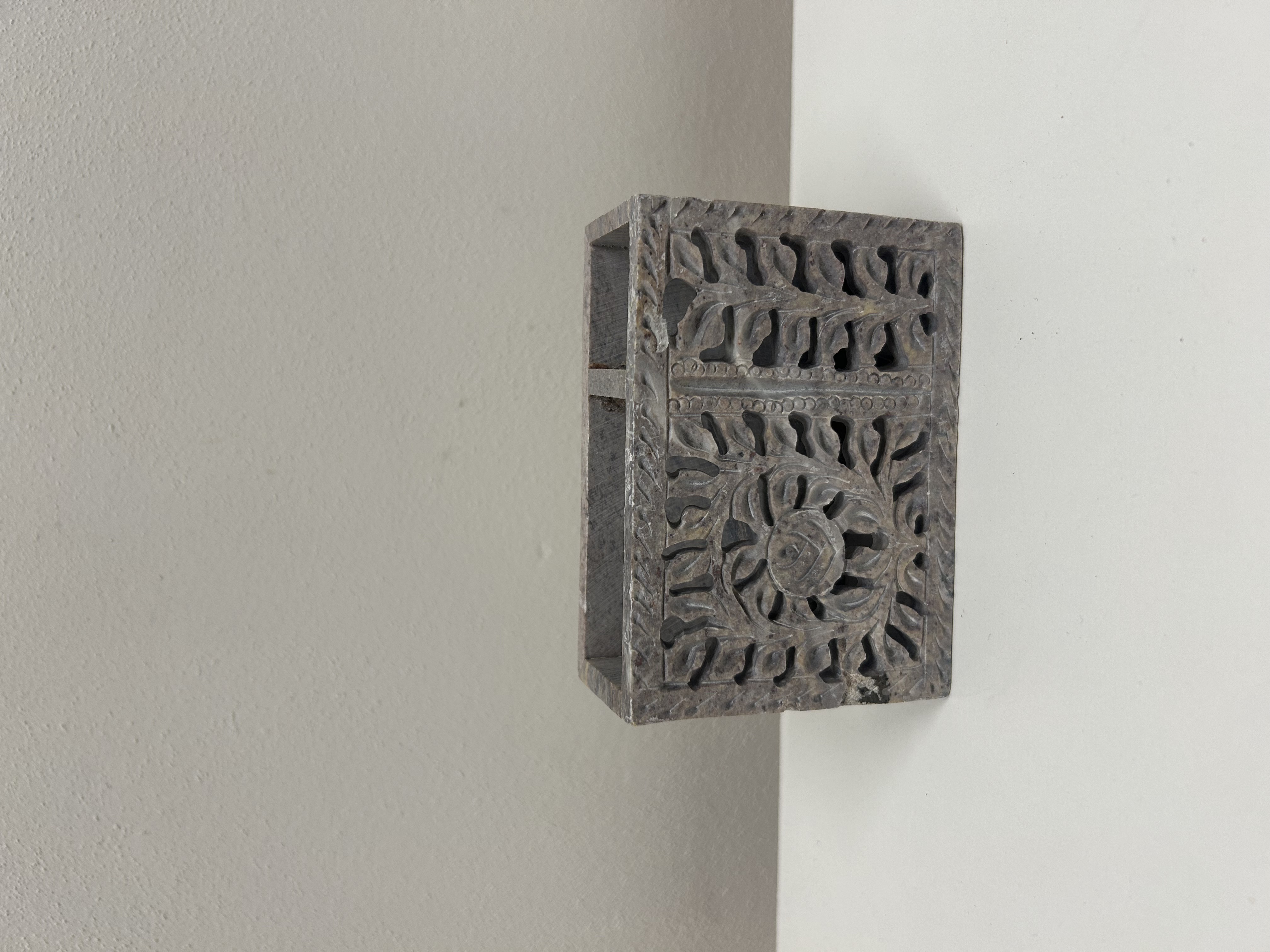 Kamenný stojan s vyřezávaným dekorem